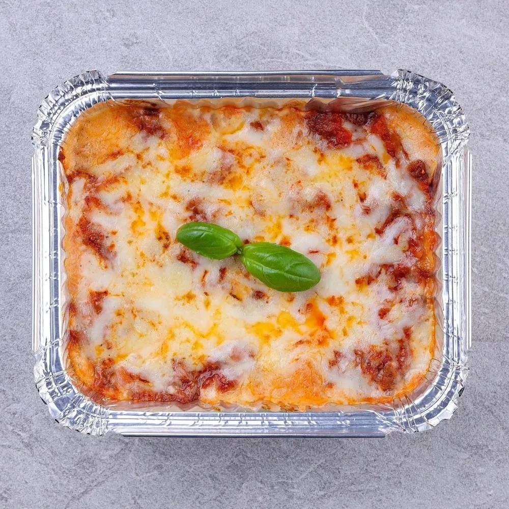 Barquette en aluminium contenant des lasagnes prêtes à servir après cuisson